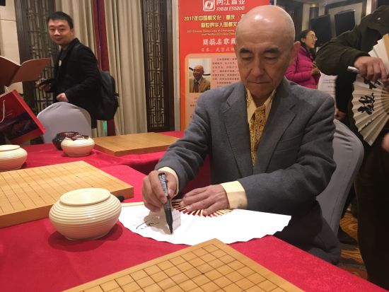 图为日本围棋超一流棋手武宫正树在签字。摄影 刘贤