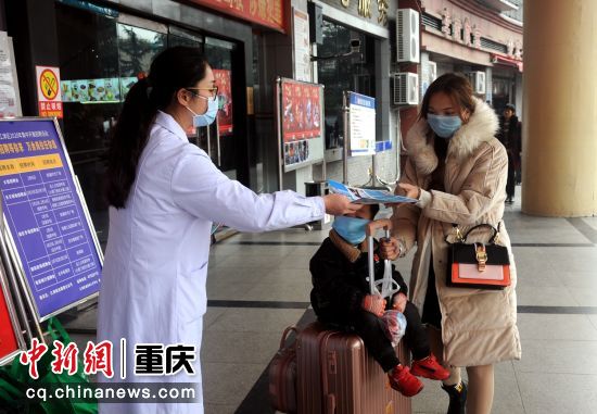 江津區疾病控制中心工作人員正在江津客運中心為過往乘客發放新冠宣傳資料，并指導口罩的正確戴法。