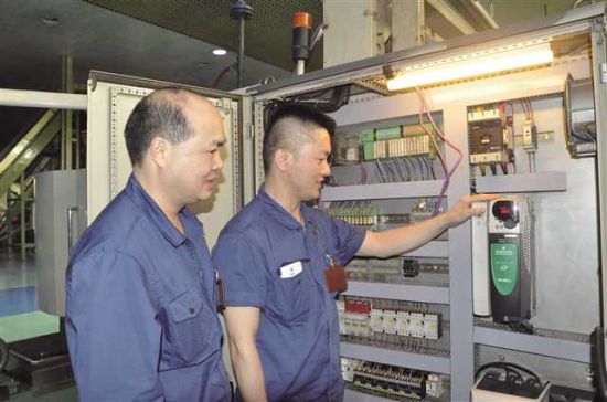 胡纪明(右)现场培训电气技术